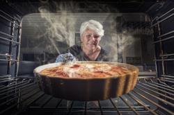 A woman pulling a pie from a Samsung Oven in Albuquerque